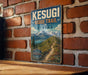 A vintage-style sign for the Kesugi Ridge Trail in Alaska, featuring a scenic mountain landscape with a winding trail.