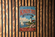 A vintage-style metal sign welcoming visitors to Kingscote, Rhode Island, with a lighthouse and sailboat in the background.