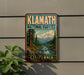 A vintage-style metal sign for Klamath National Forest in California, featuring a scenic landscape with a mountain, river, and pine trees.