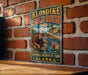 A vintage-style metal sign for Klondike Gold Rush National Historical Park in Alaska, featuring an illustration of a man panning for gold in a river.
