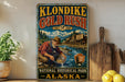 A vintage-style metal sign for Klondike Gold Rush National Historical Park in Alaska, featuring an illustration of a man panning for gold in a river.