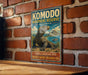 A vintage-style metal sign with a large lizard image and text, mounted on a brick wall.