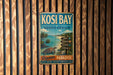 A vintage metal sign for Kosi Bay, South Africa, featuring a tropical beach scene with palm trees and a turtle.