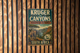 A vintage-style metal sign for Kruger to Canyons Biosphere Reserve in South Africa, featuring an illustration of an elephant and a landscape with mountains and a river.