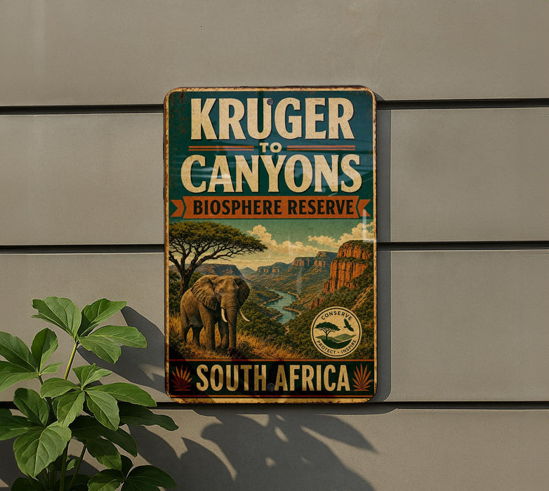 a vintage-style sign for Kruger to Canyons Biosphere Reserve in South Africa, depicting an elephant and a landscape with mountains and a river.