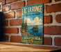 A vintage-style sign for Lac La Ronge Provincial Park in Saskatchewan, featuring a scenic landscape with pine trees, a lake, and mountains.
