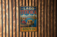 A vintage-style metal sign with the text "LAGO TITICACA BOLIVIA" displayed on a wooden wall.