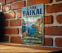 A vintage-style metal sign for Lake Baikal, the world's largest tundra reserve, mounted on a brick wall.