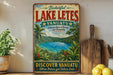 A vintage-style sign advertising Lake Letés, Vanuatu, featuring a tropical landscape with a lake, palm trees, and lush vegetation.