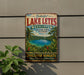 A vintage-style sign advertising Lake Letes in Vanuatu, featuring a tropical landscape with palm trees and a blue lake.