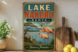 A vintage-style sign for Lake Nakuru, Kenya, featuring a flamingo and a rhinoceros in a natural landscape.