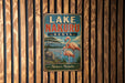A vintage metal sign for Lake Nakuru, Kenya, featuring a flamingo and a rhinoceros in a natural landscape.