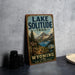 A vintage-style sign for the Lake Solitude Trail in Wyoming, featuring a scenic mountain landscape and a trail sign.