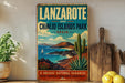 A vintage-style sign for Lanzarote and Chinjo Islands Park in Spain, featuring a scenic landscape with mountains, a sailboat, and desert plants.