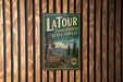 A vintage metal sign for Latour State Forest in California, featuring a scenic illustration of the forest and mountains.