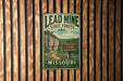 A vintage metal sign for the Lead Mine State Forest in Missouri, featuring a scenic mountain landscape and trail information.