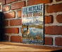 A vintage-style sign for the Lee Metcalf National Wildlife Refuge in Montana, featuring a goose and a mountain landscape.
