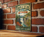 A vintage-style metal sign for Litchworth State Park in New York, featuring a scenic waterfall and lush greenery.