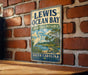 A vintage-style metal sign for the Lewis Ocean Bay Heritage Preserve in South Carolina, featuring an illustration of a heron and a turtle in a tropical setting.