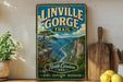 A vintage-style sign for Linville Gorge Trail, featuring a scenic mountain landscape with a winding river, surrounded by lush greenery.