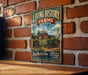 a vintage-style metal sign with a farm scene and a tractor, mounted on a brick wall.