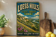 A vintage-style metal sign for Loess Hills State Forest, Iowa, featuring a scenic landscape with a winding river and lush greenery.