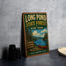 A vintage-style sign for Long Pond State Forest in New York, featuring a scenic illustration of a lake, forest, and canoe.
