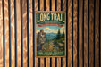 A vintage-style metal sign for the Long Trail in Vermont, featuring a scenic mountain landscape and directional signs.