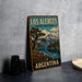 A vintage-style metal sign for Los Alerces, a national park in Argentina, featuring a scenic landscape with a lake and mountains.
