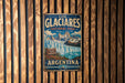 A vintage-style metal sign for the Los Glaciores National Park in Argentina, featuring a scenic image of the park's waterfall and mountains.