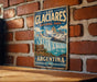 A vintage metal sign for the Los Glaciers National Park in Argentina, featuring a scenic illustration of the park's natural beauty.