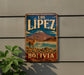 A vintage-style metal sign with the text "LOS LIEPZ BOLIVIA" and an illustration of a llama standing in front of a mountain.