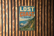 A vintage-style metal sign that reads "LOST COAST TRAIL" is mounted on a wooden wall.