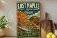 A vintage-style sign for Lost Maple State Natural Area in Texas, featuring a scenic landscape with a river, mountains, and autumn foliage.