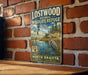 A vintage-style metal sign for the Lostwood National Wildlife Refuge in North Dakota, featuring an illustration of a heron and a serene landscape.