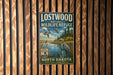 a vintage-style metal sign for the Lostwood National Wildlife Refuge in North Dakota, with a serene landscape of a lake, trees, and birds.