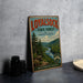 A vintage-style metal sign for the Loyalsock State Forest in Pennsylvania, featuring a scenic mountain landscape with a river and pine trees.