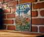 A vintage-style metal sign with the text "M'Goun Park - Morocco" is displayed on a brick wall.