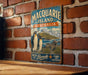 A vintage-style metal sign with the text "Mascaride Island Australia" and an illustration of penguins and a seal, mounted on a brick wall.