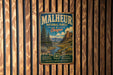 A vintage-style metal sign for the Malheur National Forest in Oregon, featuring a scenic landscape with mountains, trees, and a river.