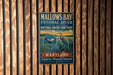 A metal sign for Mallow's Bay-Potomac River National Marine Sanctuary, featuring a blue bird and a whale, is displayed on a wooden wall.