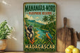 A vintage-style sign for the Mananara-Nord Biosphere Reserve in Madagascar, featuring a lush tropical landscape with a lemur and a kingfisher bird.