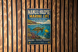 A metal sign with a colorful illustration of marine life, including a turtle and fish, is displayed on a wooden wall.