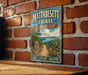 A vintage trail sign for the Mattabesett Trail in Connecticut, featuring a scenic landscape with a path leading through a wooded area.
