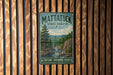 A vintage metal sign for Mattatuck State Forest in Connecticut, featuring a scenic illustration of a forest landscape with a river and mountains.