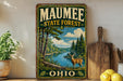 A vintage-style sign for the Maumee State Forest in Ohio, featuring a deer in a forest setting with a river and pine trees.