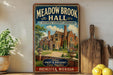 a vintage-style sign for Meadow Brook Hall, a historic landmark in Rochester, Michigan. The sign displays a large illustration of the building surrounded by trees and a path, with the text "Meadow Brook Hall" prominently featured.