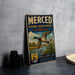 A vintage-style sign for the Merced National Wildlife Refuge in California, featuring an illustration of a duck and a bird in flight over a body of water.