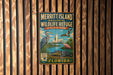 A vintage-style metal sign for the Merritt Island National Wildlife Refuge in Florida, featuring illustrations of various birds and wildlife.