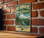A vintage-style metal sign for the Mesomorphic State Forest in Connecticut, featuring a scenic landscape with a river and mountains.